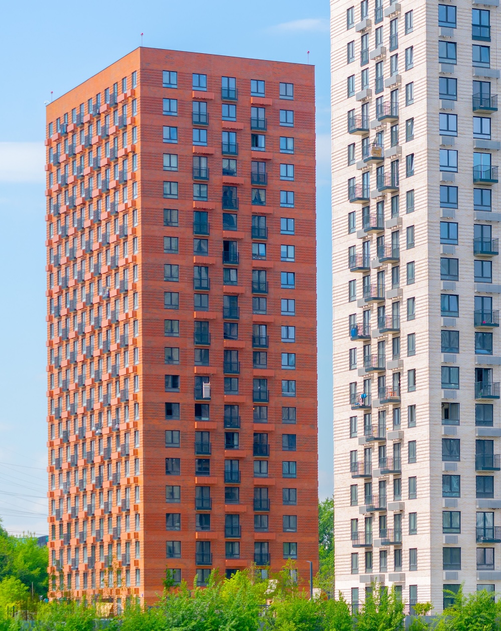 The beautiful exterior of modern skyscrapers against a blue cloudy sky during daytime